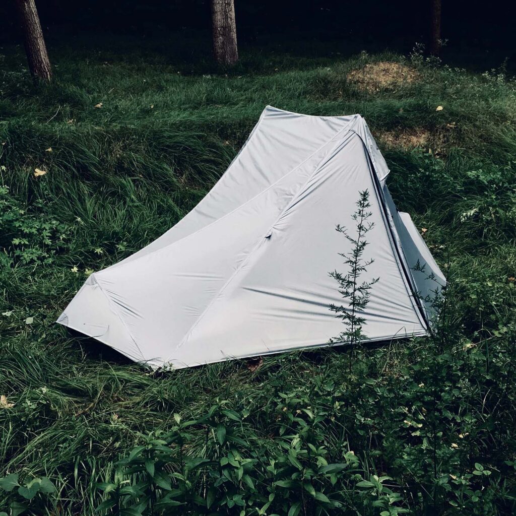 A white camping tent on green grass