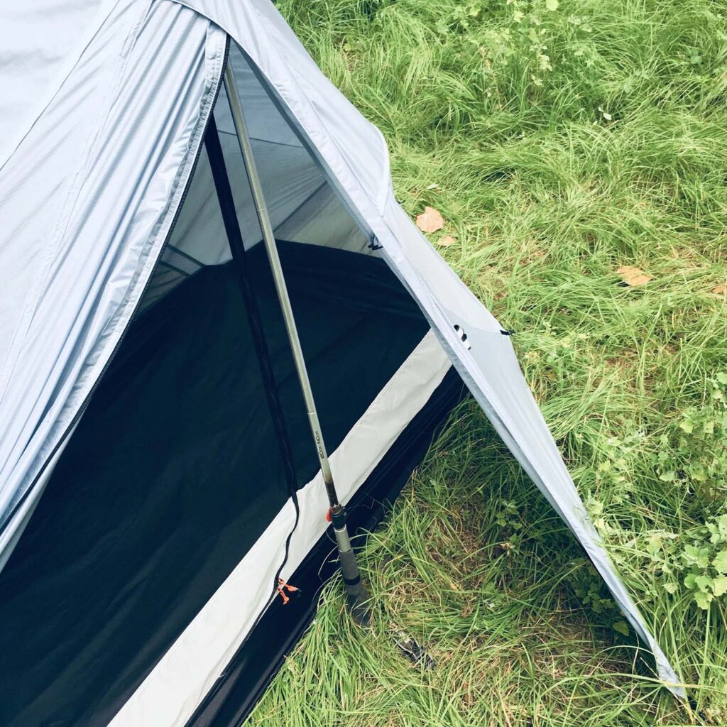 A white camping tent on green grass