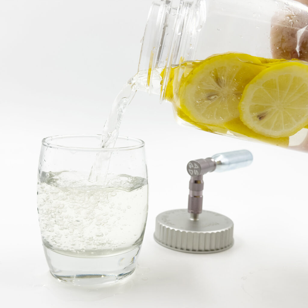 Pouring sparkling lemon water from a bottle into a glass.