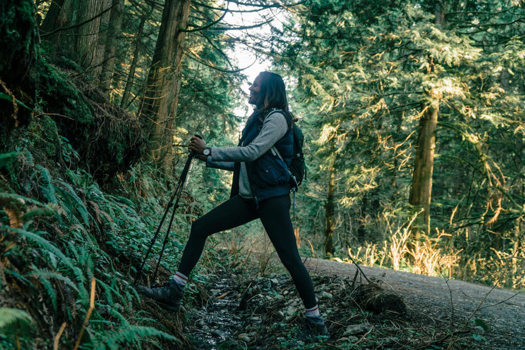 Hiker with hiking poles on a forest trail