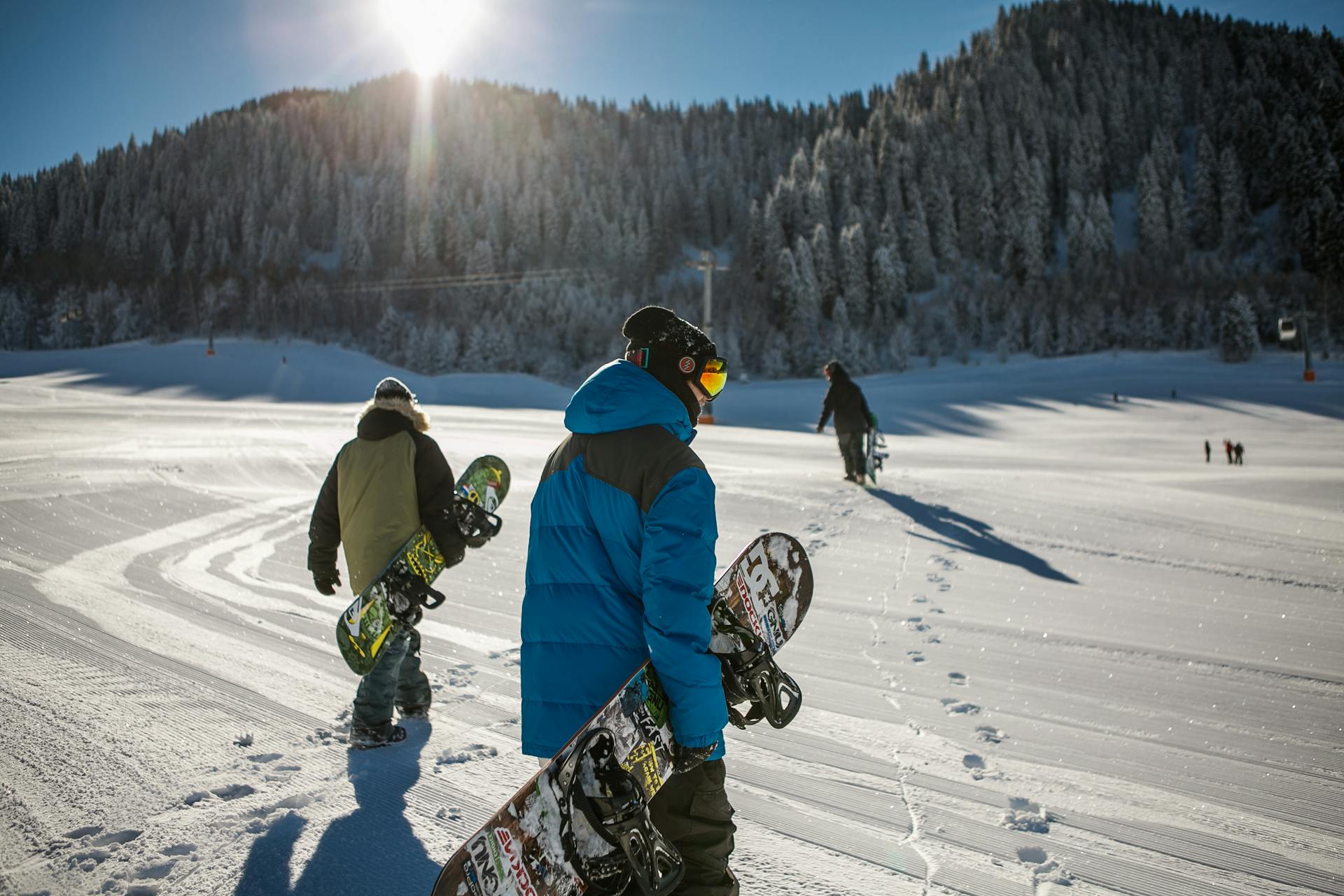 person-wearing-blue-winter-jacket-carrying-snowboard-under-sunny-sky Photo by Visit Almaty