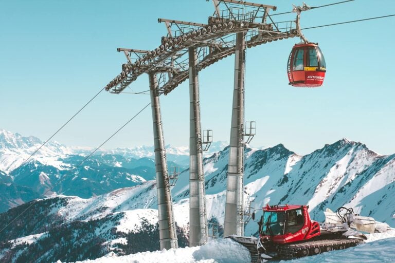 Ski lift climbing a powder-covered slope with mountain peaks behind at Jackson Hole Mountain Resort-photo-by-pexels