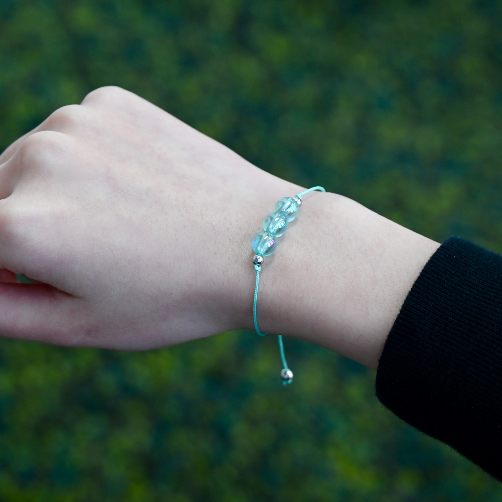 Asgard Alpine ID translucent cyan bracelet worn on wrist with three translucent cyan beads and matching adjustable cord.