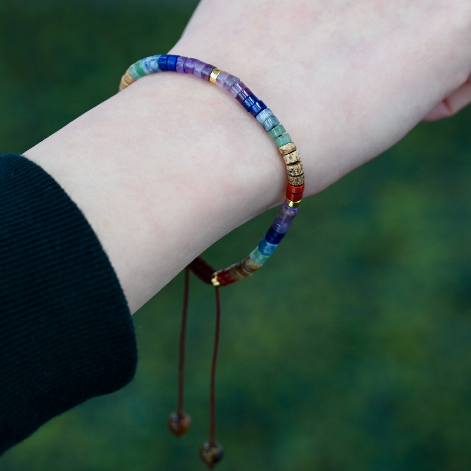 Close side view of Asgard Strata ID layered natural stone bracelet on wrist with colorful disc beads and adjustable cord.