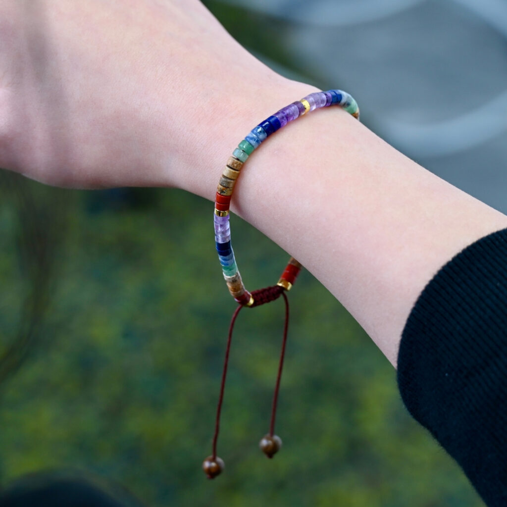Asgard Strata ID layered natural stone bracelet worn on wrist outdoors, showing multicolor disc beads and sliding cord.