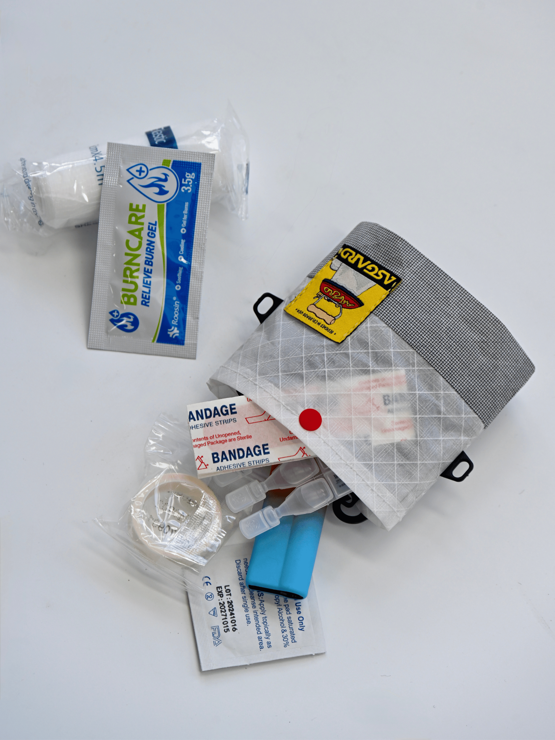 Asgard Mini Tote Bag beside bandages, gauze, tape, and other compact first-aid supplies on a white surface.