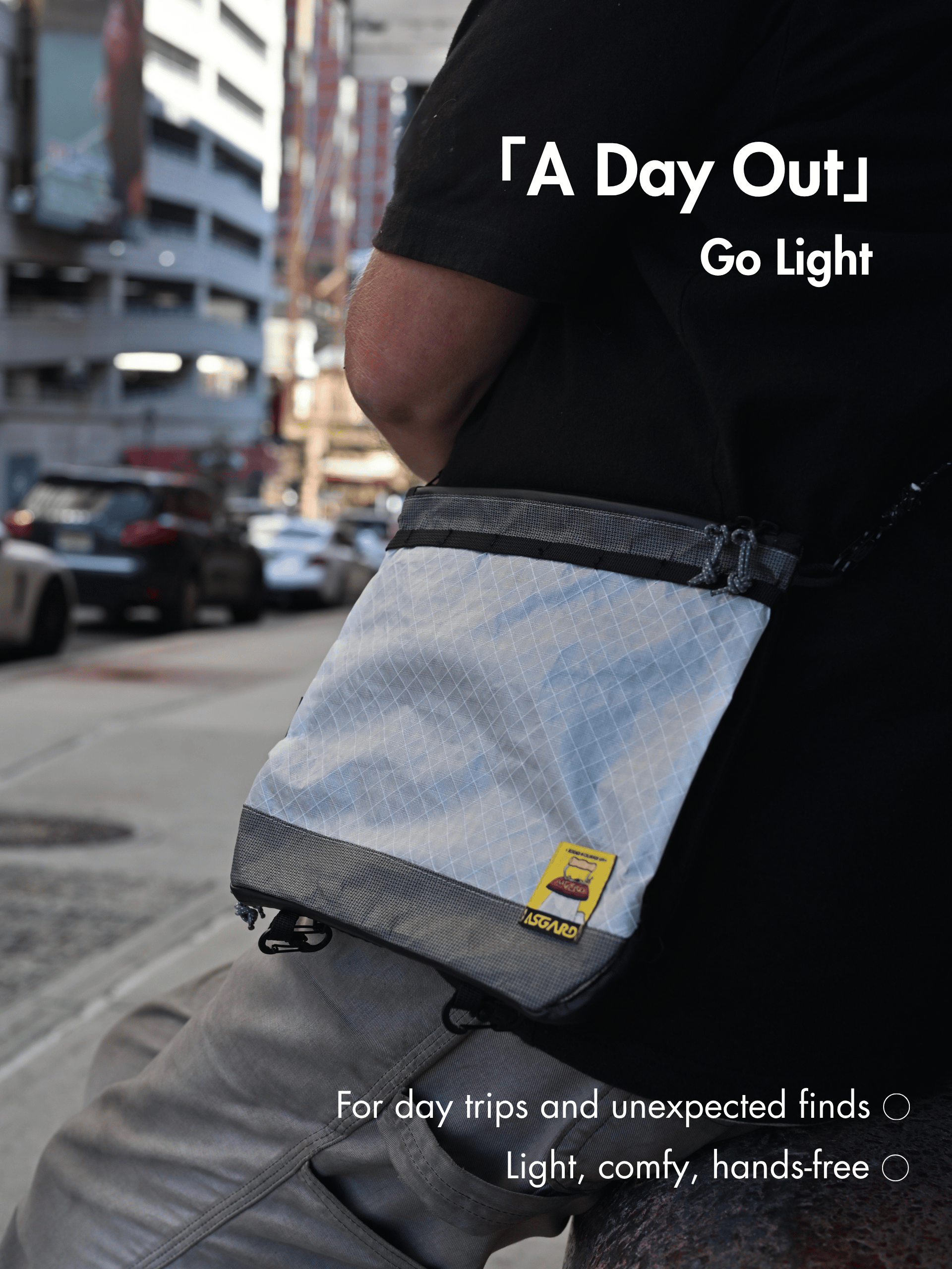 Person wearing the Asgard Versa Bag 5L at the hip on a city street, beneath the headline A Day Out. Go Light.