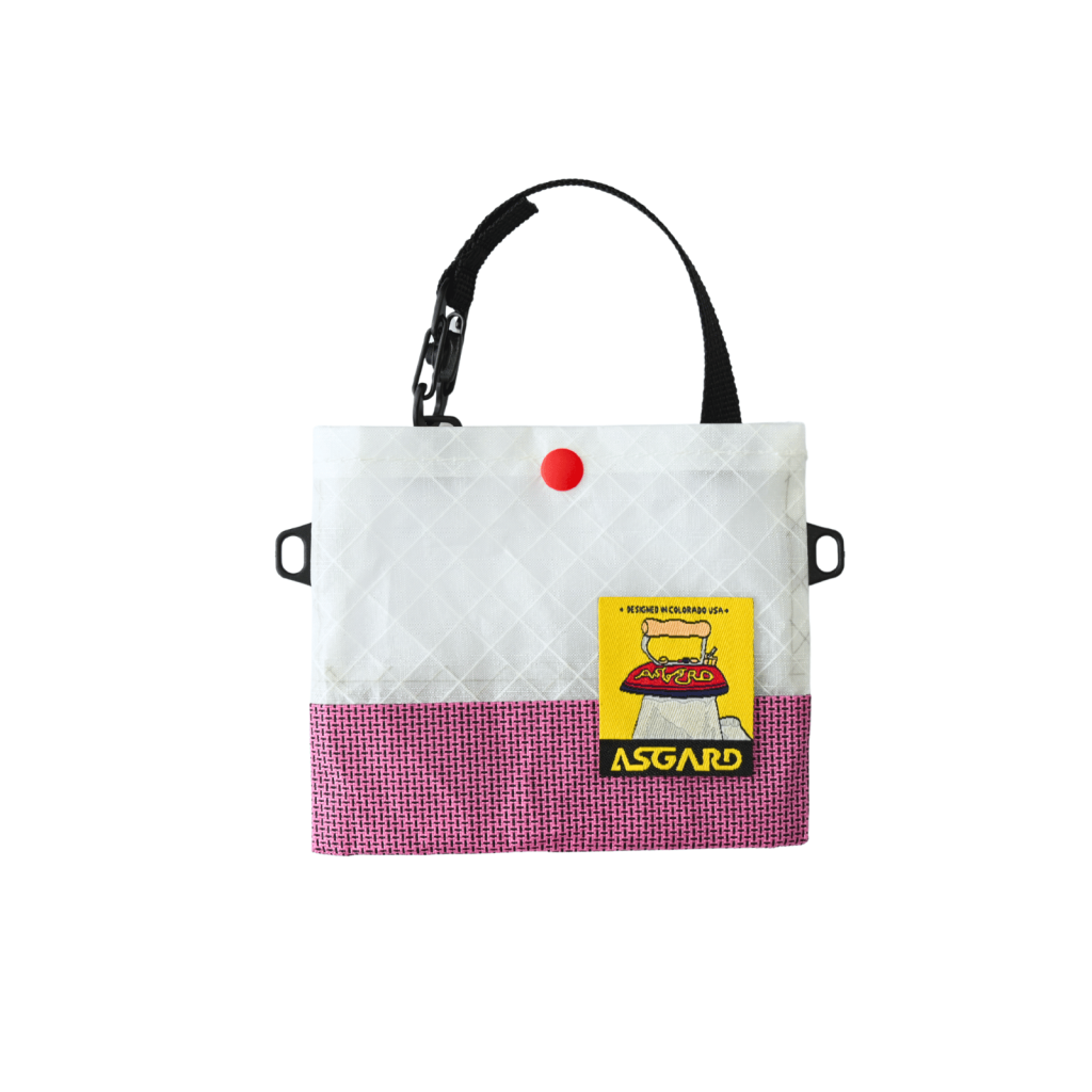 Pink Asgard Mini Tote Bag with a white upper panel, black handle, red snap, and yellow logo patch.
